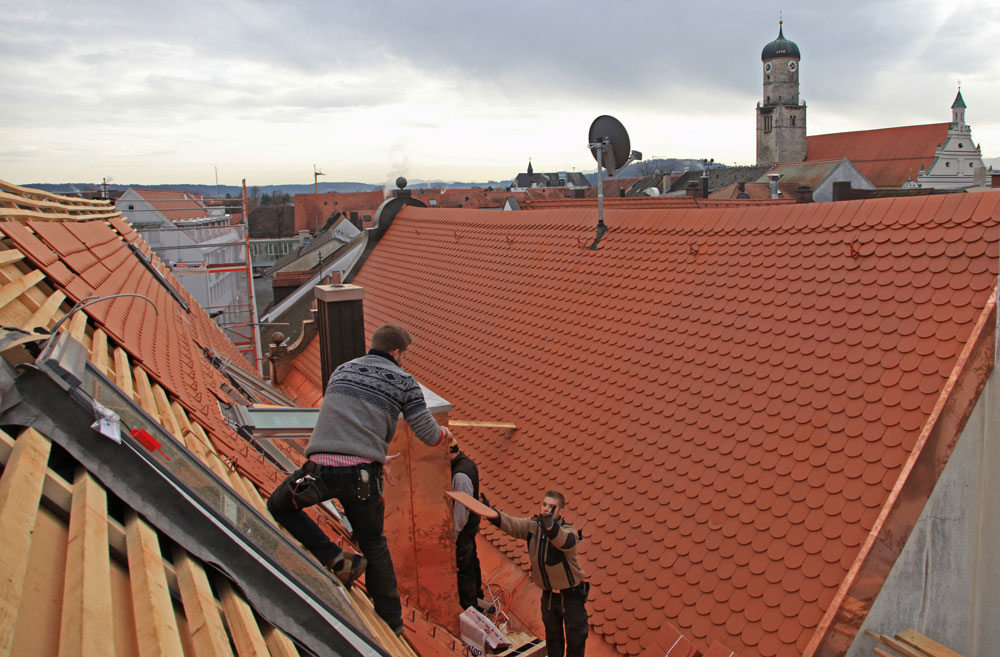 Aufnahme eines Daches mit einem arbeitenden Dachdecker aus der Vogelperspektive